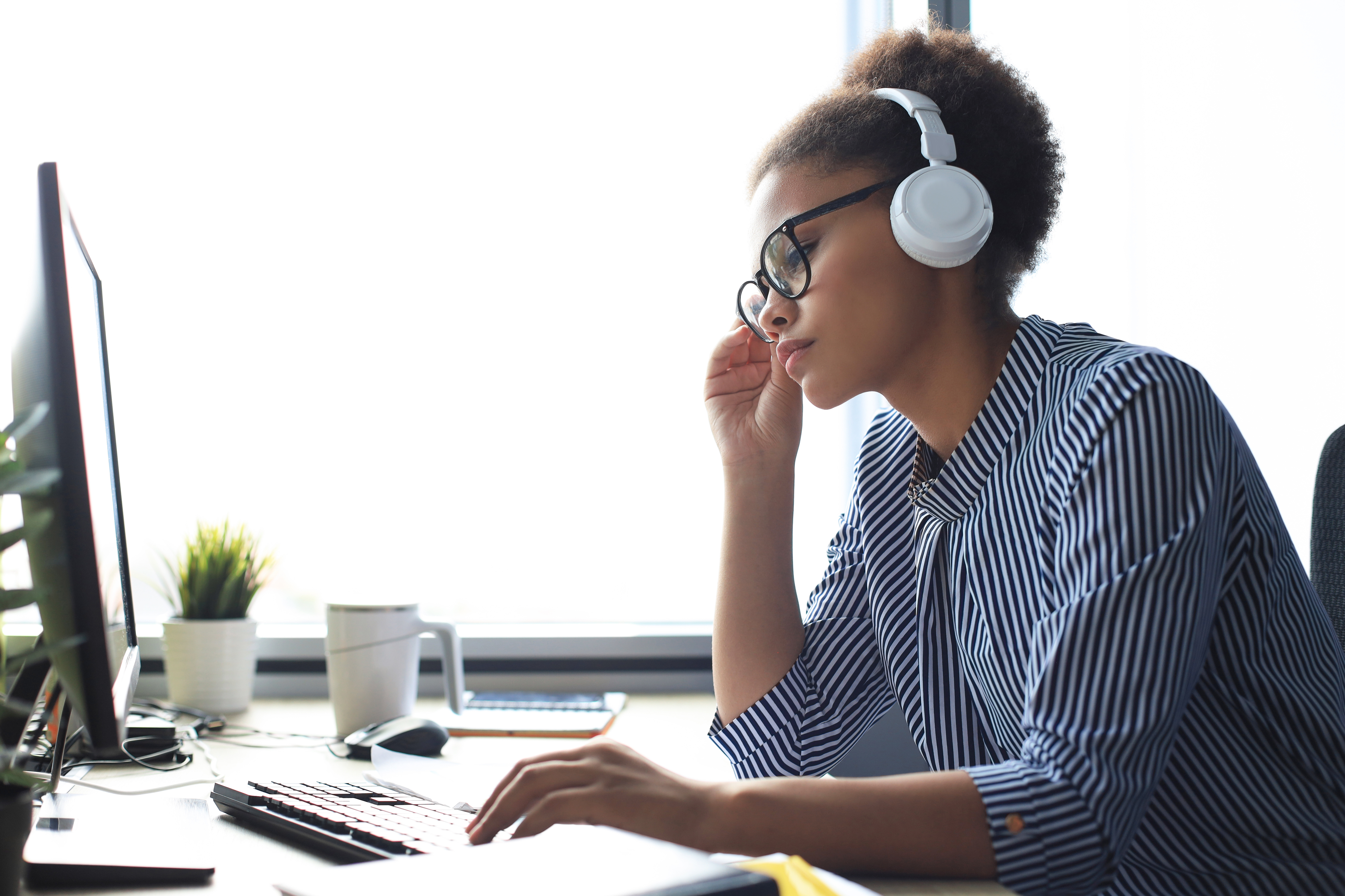 young woman researching online wearing headphones