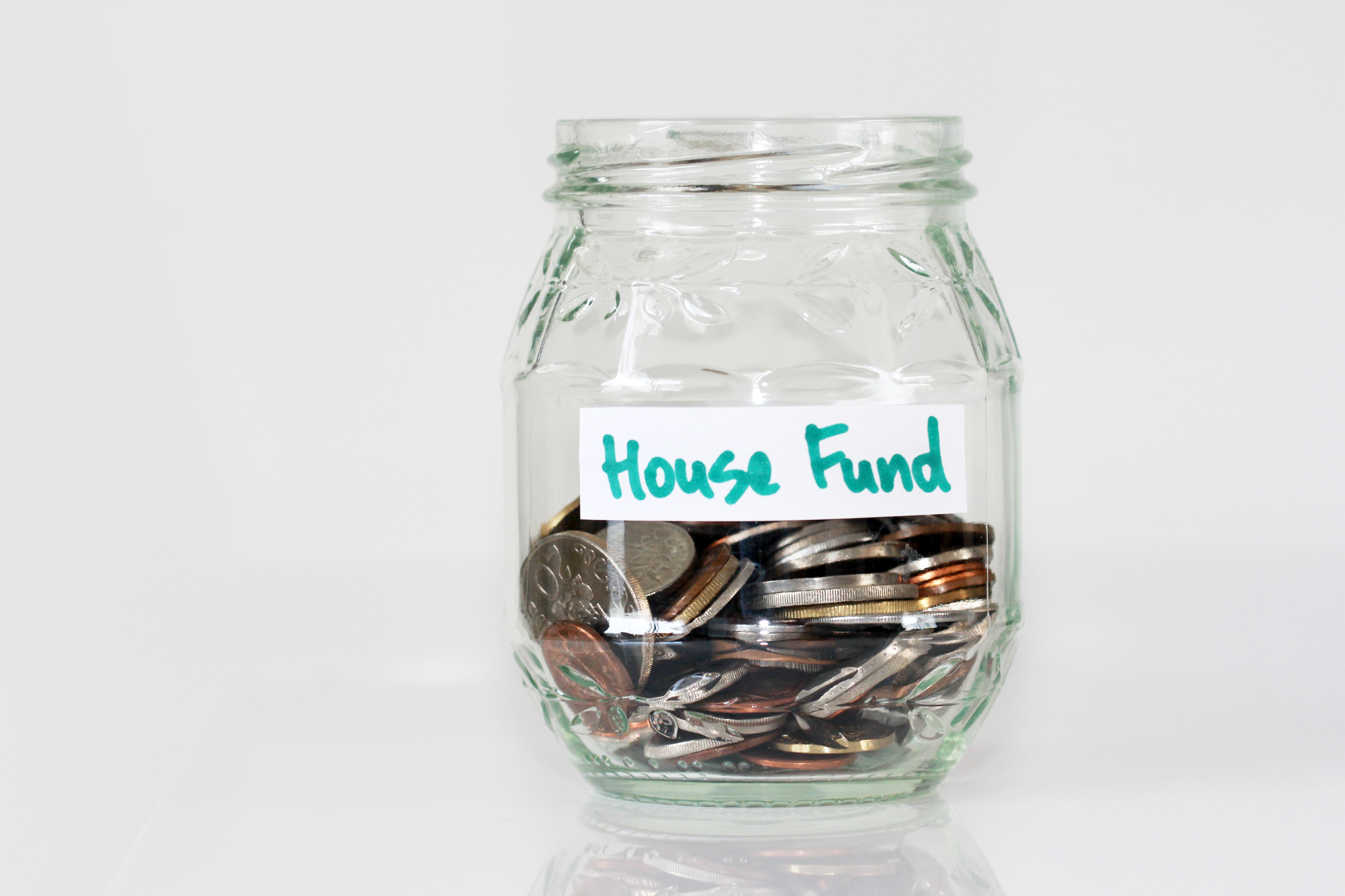 saving pennies in jar labelled house fund 