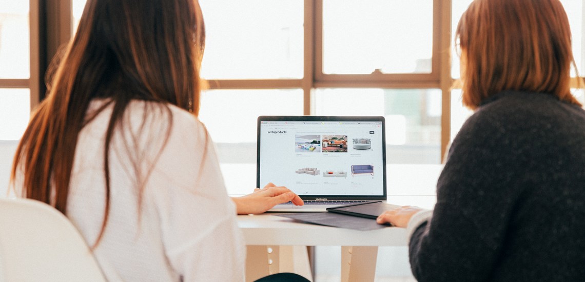 two women looking at laptop research