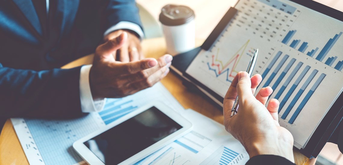 adviser explaining graph to client on laptop