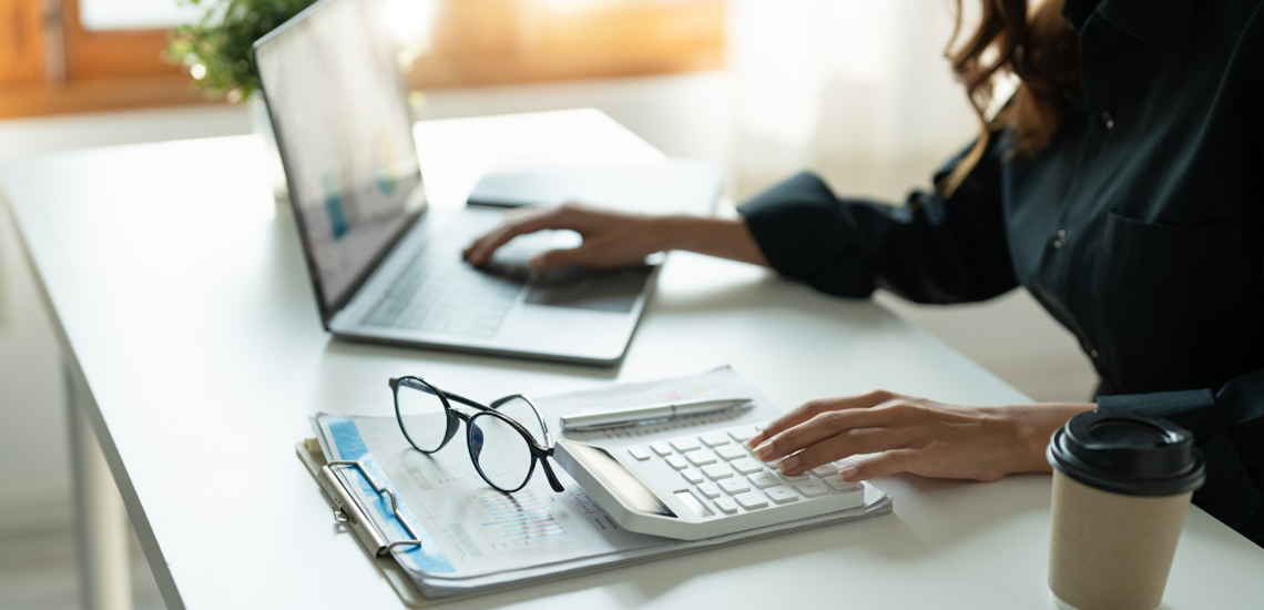 Self-Employed woman working on a laptop from her desk.