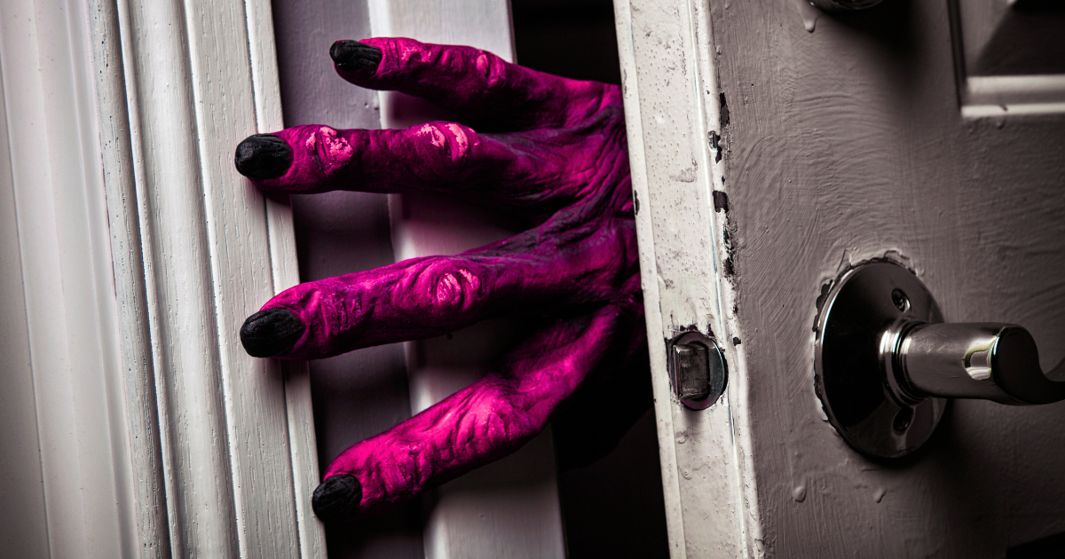 Big, purple monster hand reaching around a doorframe.