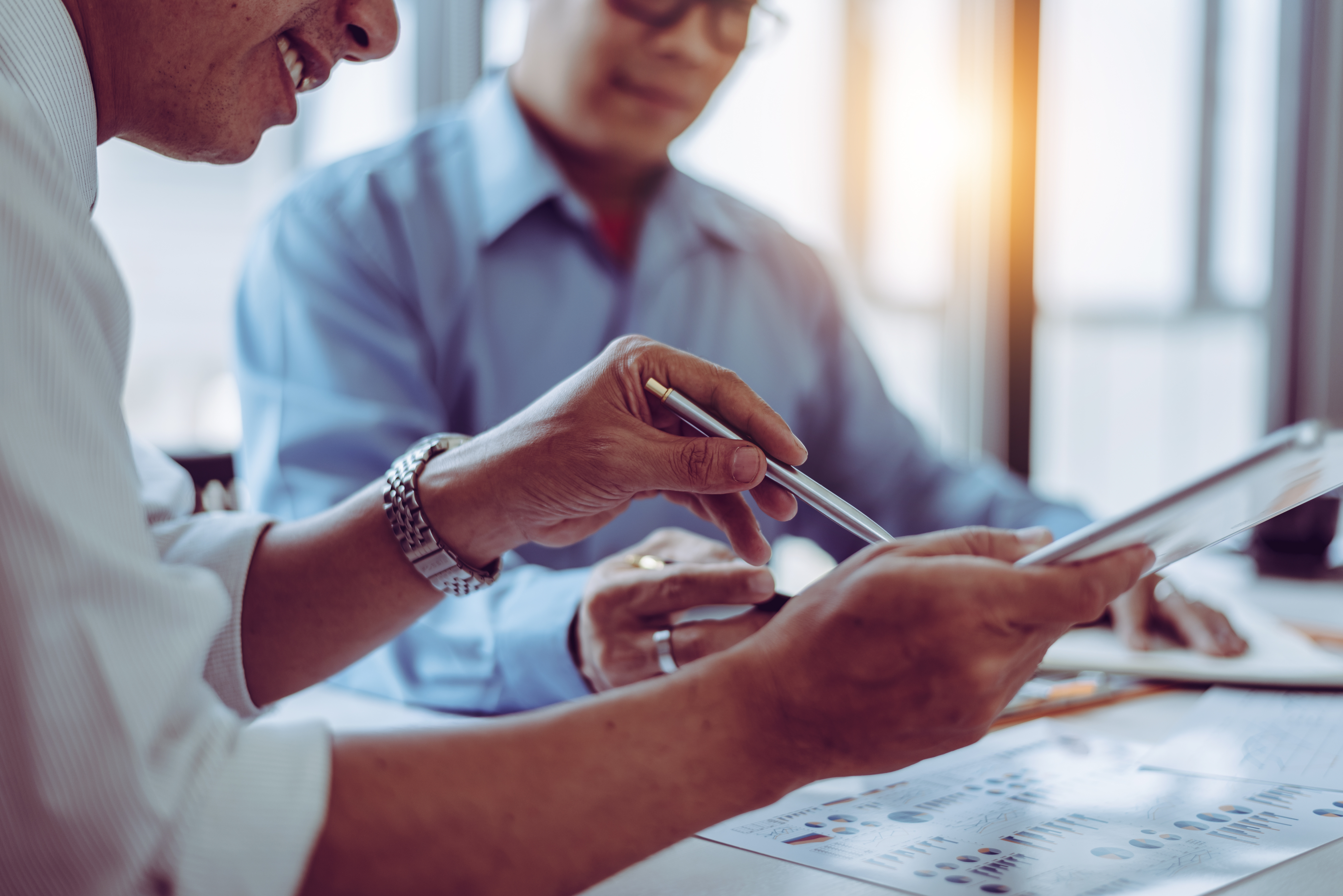 two people sitting at a table looking at graphs